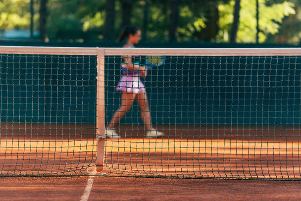 Досить жіночий тенісистка спостерігається через мережу
. - Фото, зображення