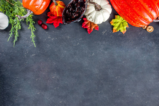 Festive thanksgiving day holiday background. White orange pumpkins, colorful autumn leaves, berries, on  dark concrete background top view frame copy space - Foto, Imagem
