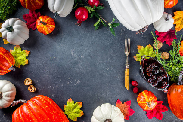 Thanksgiving Tisch Deckung Hintergrund. Weiße orangefarbene Kürbisse, bunte Herbstblätter, Beeren mit Gabeln, auf dunklem Betonhintergrund - Foto, Bild