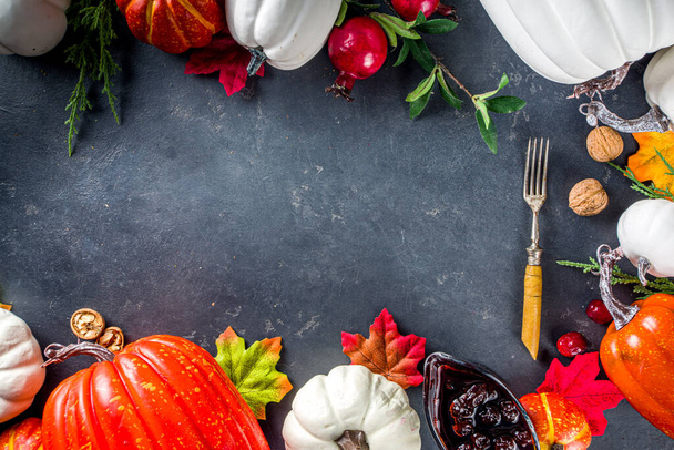 Thanksgiving Table setting Background. White orange pumpkins, colorful autumn leaves, berries with forks, on  dark concrete background top view frame copy space - Photo, Image