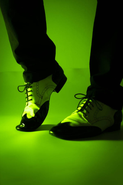 Αντρας χορευτής χορεύει σε τζαζ λάτιν παπούτσια αίθουσα χορού με φόντο απλό χρώμα - Φωτογραφία, εικόνα