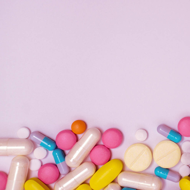 Hromada léků v kapslích a pilulky různých barev na bílém pozadí - Fotografie, Obrázek
