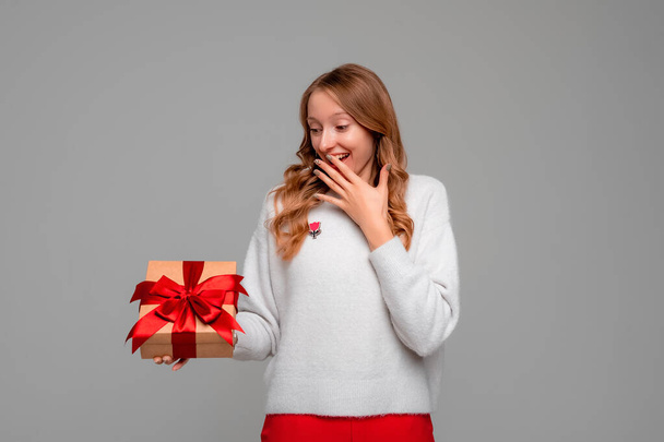 Gelukkige jonge vrouw in de hand unboxxed cadeau. Vrouwelijke persoon genieten van langverwachte verjaardagscadeau, dromen uitkomen. Vakantie, feest en lifestyle concept - Foto, afbeelding