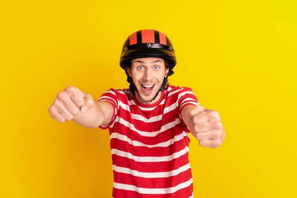 Portrait of attractive cheerful childish guy riding invisible car having fun isolated over bright yellow color background - Foto, immagini