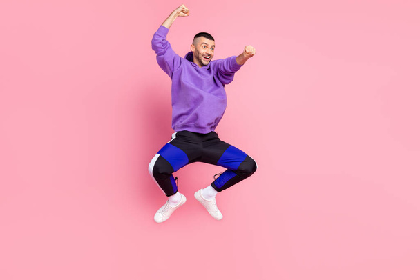 Full size photo of funny millennial brunet guy ride wear hoodie pants shoes isolated on pink background - Fotografie, Obrázek