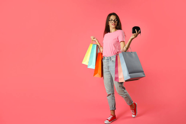 Attractive girl with multicolored paper bags on pink background. - Φωτογραφία, εικόνα