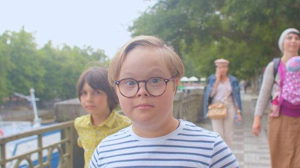 Down syndrome boy moves family around city. He uses glasses improve his vision. - Φωτογραφία, εικόνα