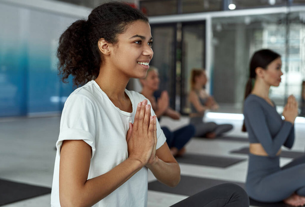 Sorridente donna etnica sportiva meditare pratica yoga - Foto, immagini