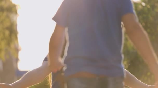 eine junge Mutter mit einem fröhlichen Lächeln umarmt ihren kleinen Sohn im Stadtpark, Muttertag, eine glückliche Familie, ein gütiger Elternteil geht mit einem Kind, ein Kind mit einem geliebten Menschen, mütterliche Fürsorge und liebevolle Hände - Filmmaterial, Video