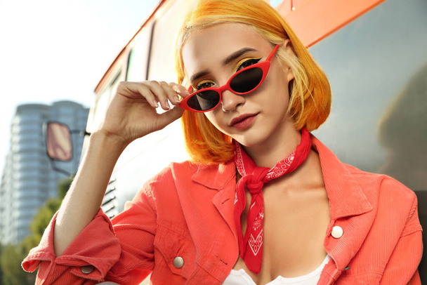 Beautiful young woman with bright dyed hair in sunglasses outdoors - Fotoğraf, Görsel