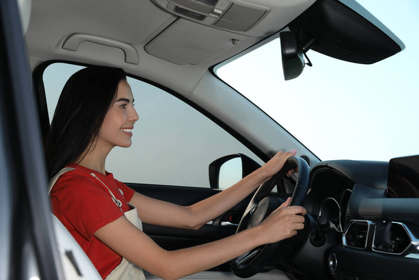 Beautiful young woman driving her modern car - Photo, image