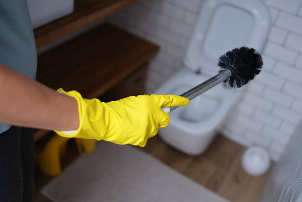 Hand in a glove holds a toilet brush, close-up - Photo, Image