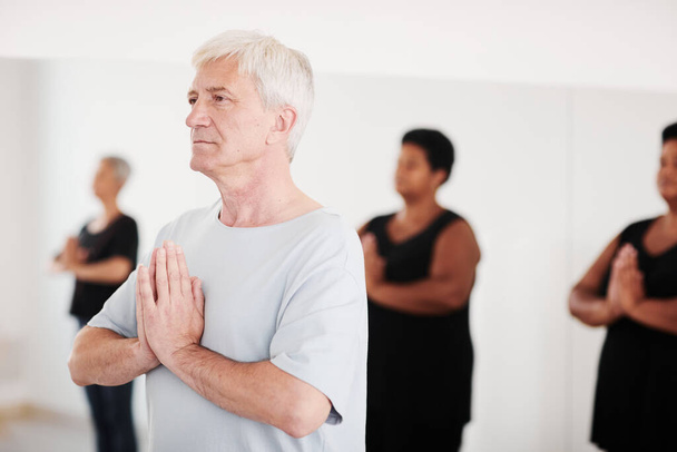 Homme âgé méditant pendant le cours de yoga - Photo, image