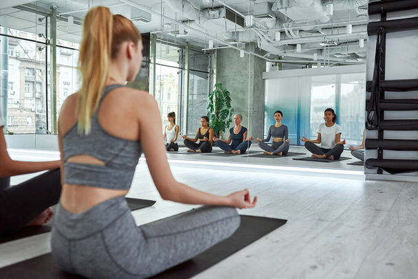 Multiethnic women group practice yoga at training - Foto, Imagen