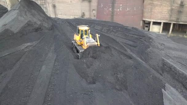 Bulldozer tractor collecting black coal on supply field of thermoelectric power station - Footage, Video