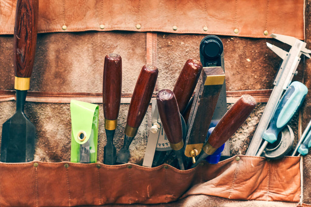 Dláto a další pracovní nástroje pro dřevoobrábění a tesařství v koženém opasku - Fotografie, Obrázek