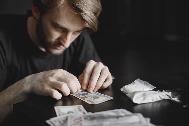 Young addicted man taking cocaine with dollar - Foto, Imagen