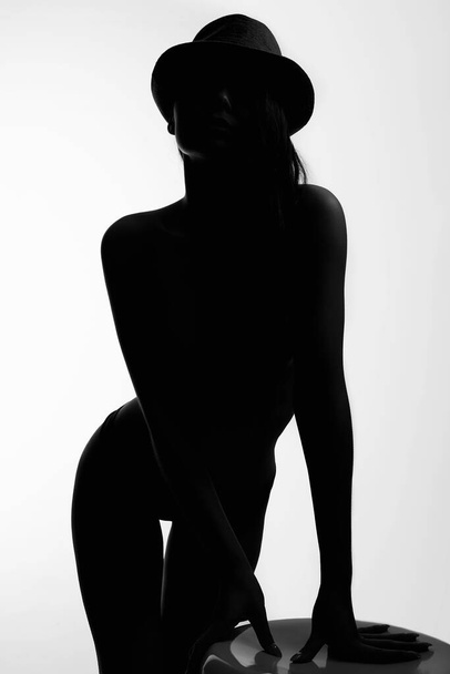 Kobieca sylwetka. Młoda Seksowna Ciało. Naga dziewczyna w kapeluszu. Czarno-biały kontur - Zdjęcie, obraz