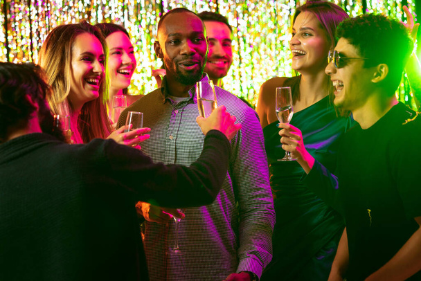Szczęśliwi radośni przyjaciele bawiący się razem w nocnym klubie, świętujący urodziny, wakacje - Zdjęcie, obraz