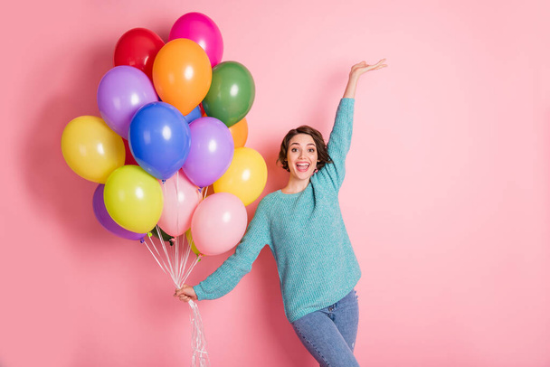 Photo of cheerful festive excited young woman raise hand hold balloons isolated on pastel pink color background - Fotoğraf, Görsel