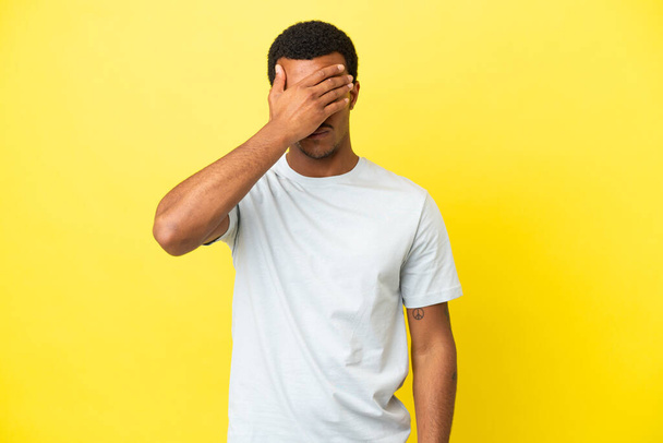 African American handsome man on isolated yellow background with headache - Foto, Imagem