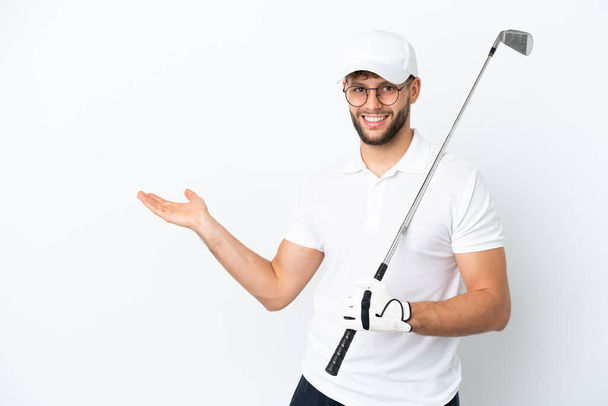 ハンサムな若い男プレイゴルフ隔離された白い背景に手を伸ばし側に招待するために来る - 写真・画像