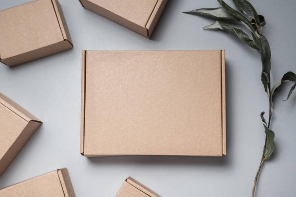 Brown flat cardboard carton box decorated with dried leaves, top - Zdjęcie, obraz