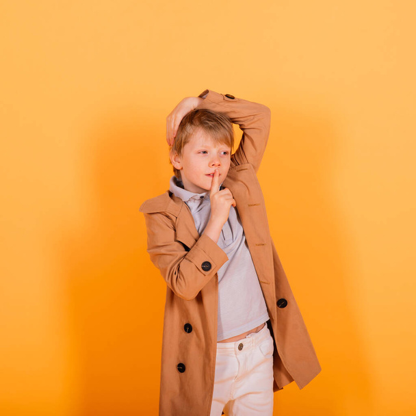 Grimacing emotional redhead fasion boy posing in a yellow studio - Foto, Bild
