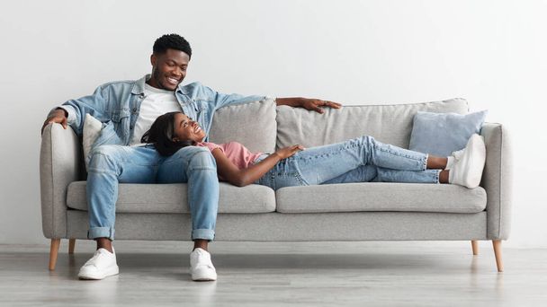 Αφροαμερικανοί ζευγάρι περνούν το Σαββατοκύριακο μαζί ξαπλωμένοι στον καναπέ - Φωτογραφία, εικόνα
