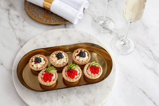 canape with black caviar and soured cream near glass with champagne - Φωτογραφία, εικόνα