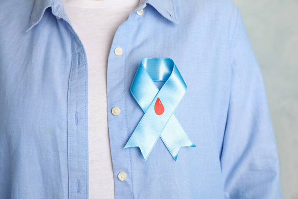 Woman with light blue ribbon and paper blood drop, closeup. World Diabetes Day - Φωτογραφία, εικόνα