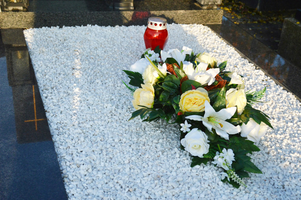 Flowers and candle on the grave - Photo, Image
