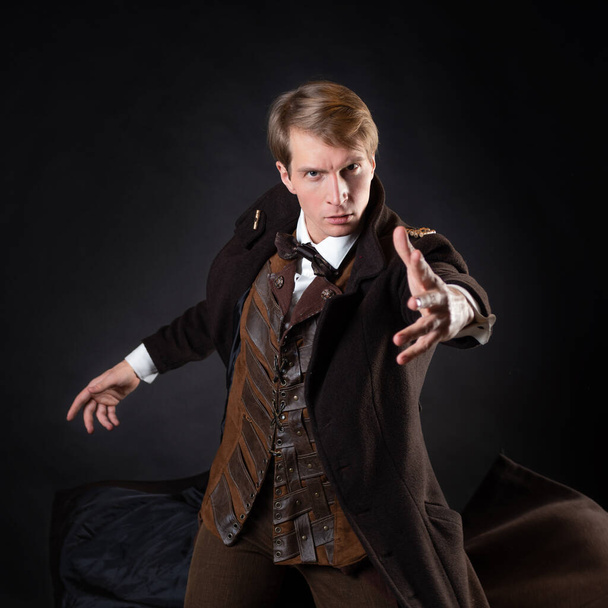 character of the steampunk story, a young attractive man in an elegant long coat - Foto, Bild