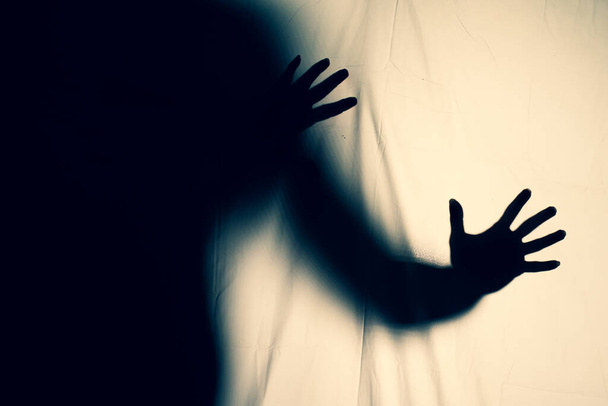 Ijesztő szellem egy fehér lepedős rémálomban. ijesztő kép a függöny mögötti kezekről. halloween ötlet - Fotó, kép