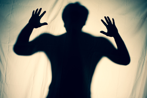frightening ghost in a white sheet nightmare. scary picture of hands behind curtain. halloween idea - Foto, afbeelding