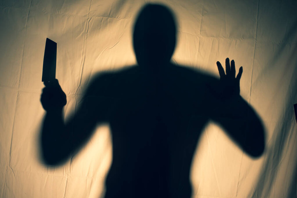 Un asesino aterrador sostiene un cuchillo en su mano detrás de un velo aterrador. idea de Halloween - Foto, imagen