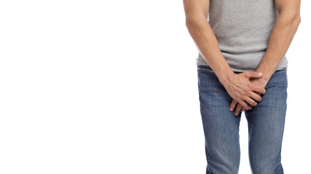 Cropped millennial european muscular male suffering from groin pain, presses hand to crotch - Photo, Image