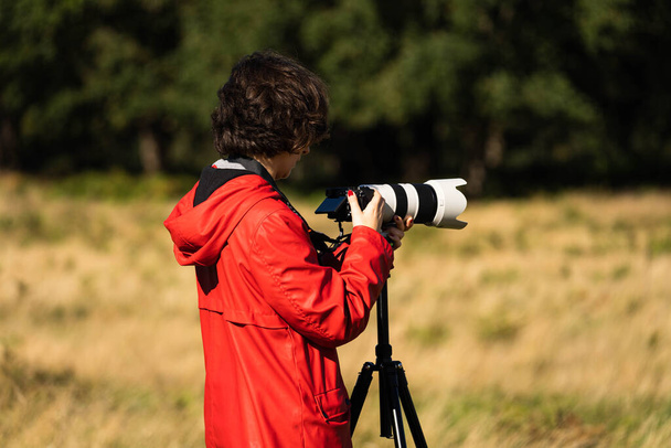 Jeune femme prenant des photos avec une lentille téléobjectif de la faune pendant la saison de rut des cerfs en automne - Photo, image