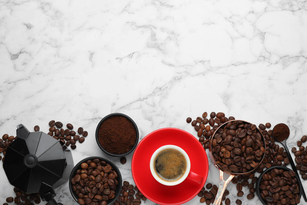 Coffee maker, beans, powder and cup of drink on white marble table, flat lay. Space for text - Фото, зображення