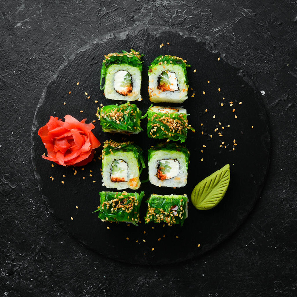 Sushi rolls with caviar, chuka salad and cheese. Traditional Japanese cuisine. Top view. - Fotografie, Obrázek
