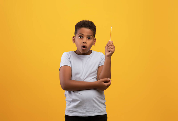 asombrado negro chico escolar levantando lápiz hasta - Foto, Imagen