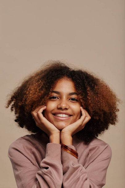Χαμογελώντας νεαρή γυναίκα με φυσικά μαλλιά - Φωτογραφία, εικόνα