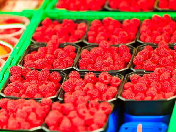 Raspberries in containers for sale at market place - Foto, afbeelding
