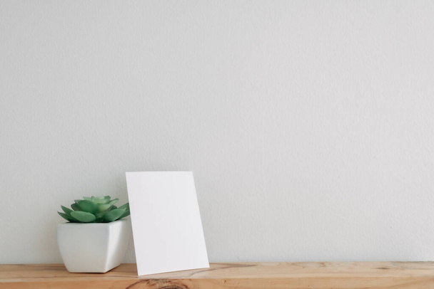 Empty postcard mockup with cactus pot on white wall. - 写真・画像