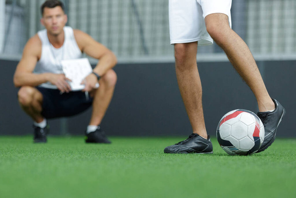 coach watching football player practice ball skills - Fotoğraf, Görsel