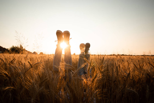 Couples legs over grain field and sky - Zdjęcie, obraz
