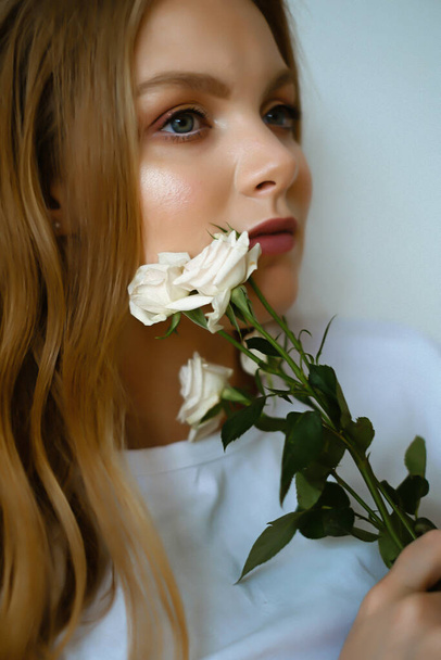 Portrait of young caucasian woman with long blond hair, girl with flowers - Foto, afbeelding