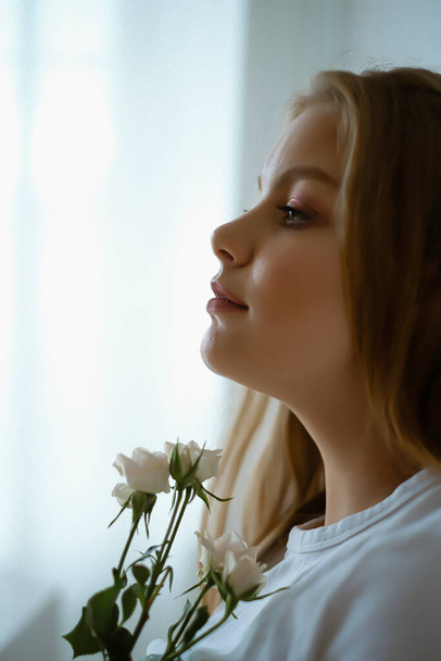 Portrait of young caucasian woman with long blond hair, girl with flowers - Photo, image