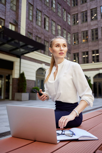 businesswoman with smartphone working at the laptop - Foto, Bild