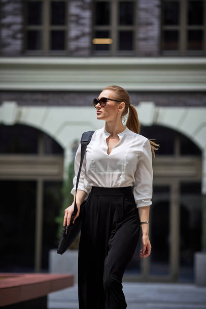 beautiful woman in sunglasses in the street - Fotó, kép